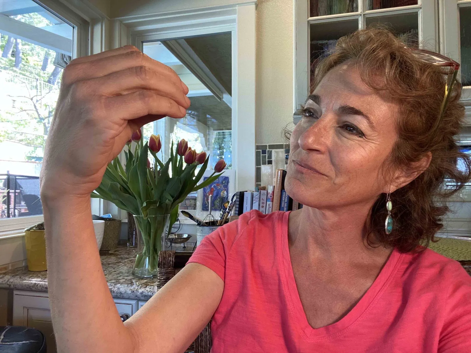 Elinor Silverstein demonstrating while looking closely at her raised hand.